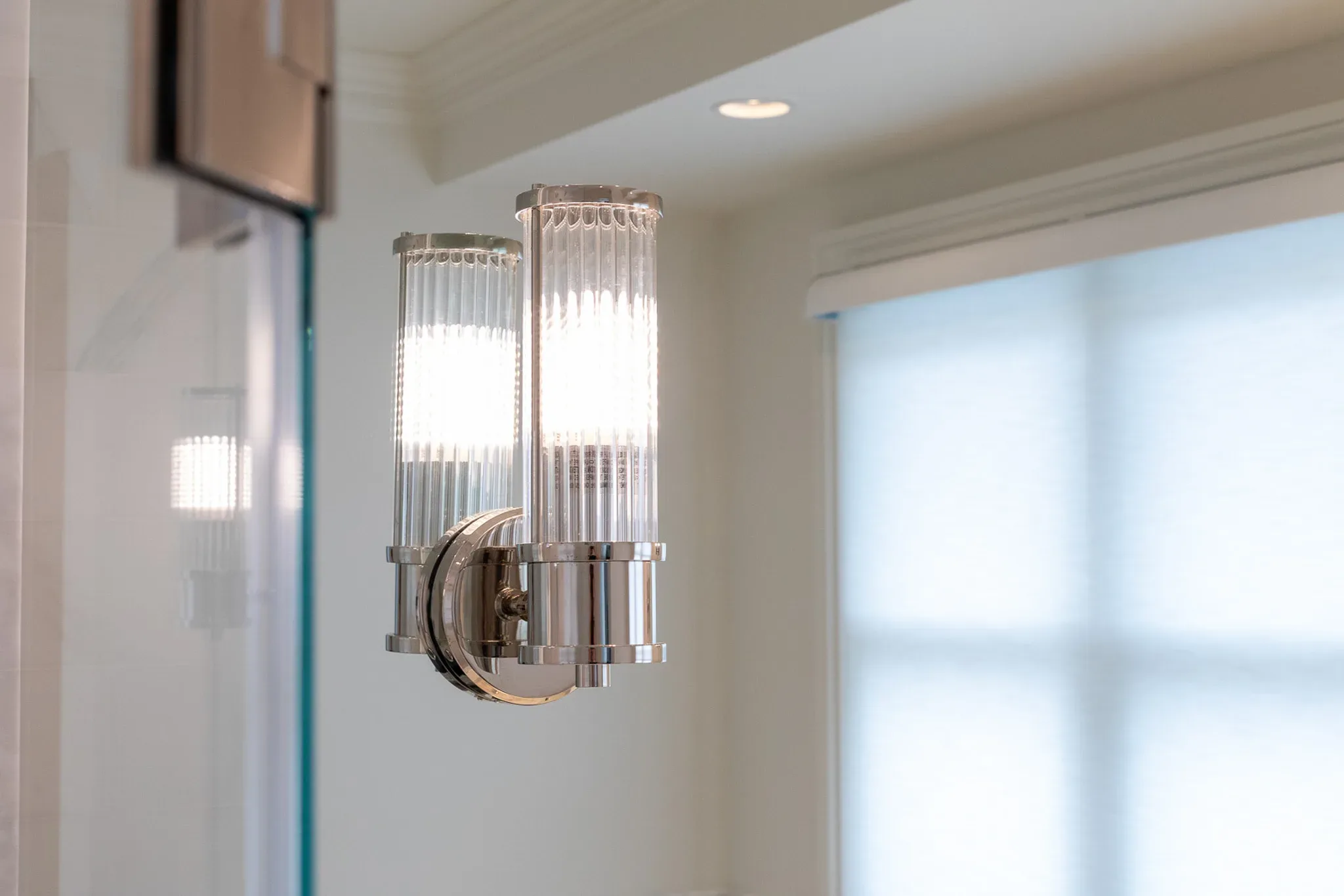 A light fixture in a bathroom with a glass door.