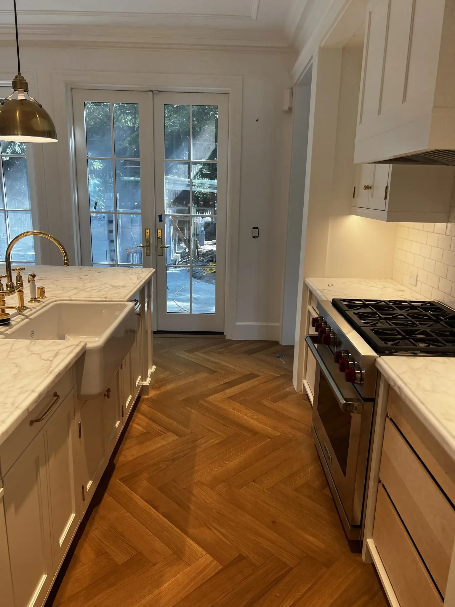 A kitchen with white cabinets and a wooden floor.